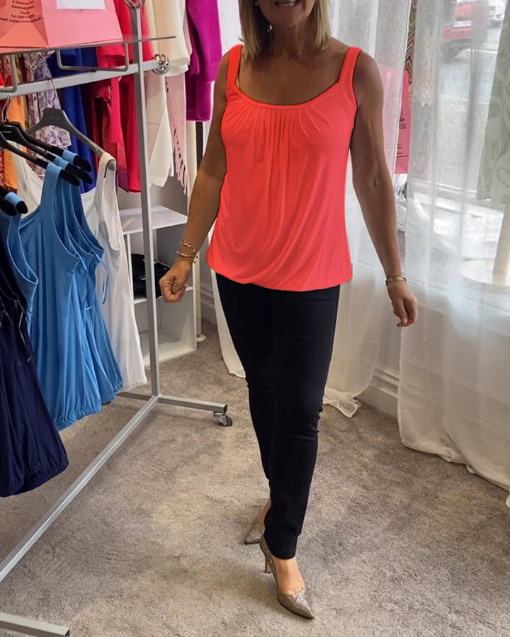 Nancy pleated sleeveless top in coral, full-length walking shot