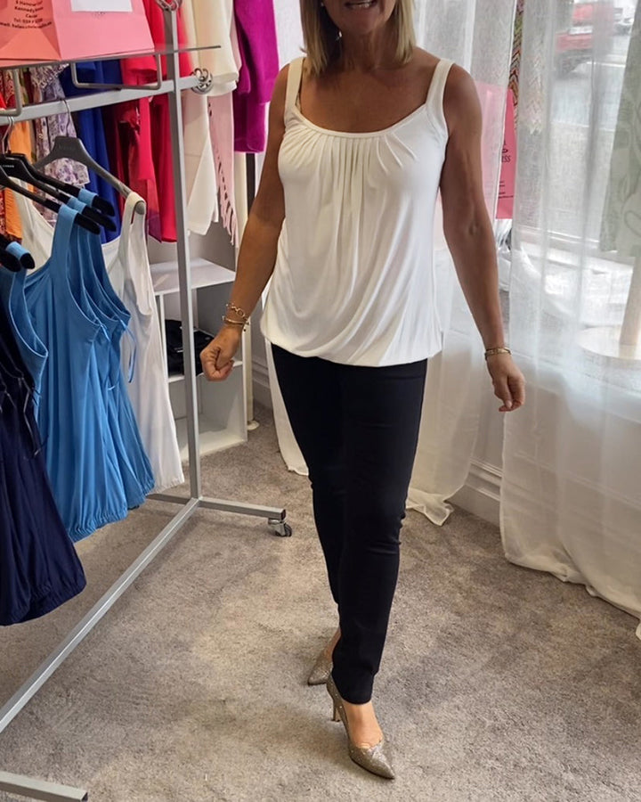 Nancy pleated sleeveless top in white, full-length walking shot